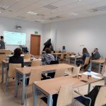 Na zdjęciu w sali wykładowej uczestnicy szkolenia pod tytułem: „Dostępność przestrzeni akademickiej dla osób z niepełnosprawnościami” z zaciekawieniem słuchają wystąpienia prelegenta.