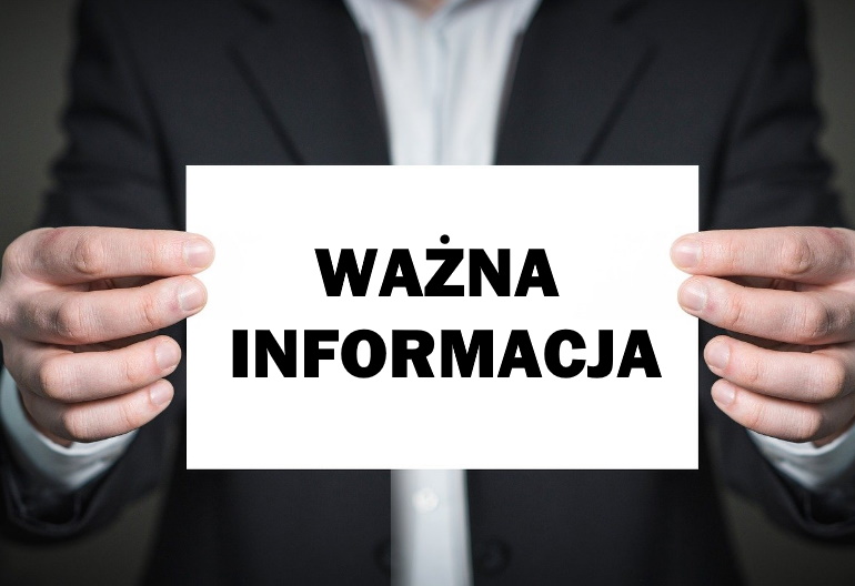 Mężczyzna ubrany w czarną marynarkę i białą koszulę trzyma oburącz jasną kartę z czarnym tekstem: ważna informacja.