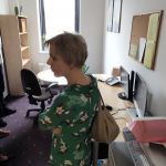 Uczestnicy w pokoju cichej pracy. Przy ścianie stoją stoliki i biurka ze sprzętem biurowym.