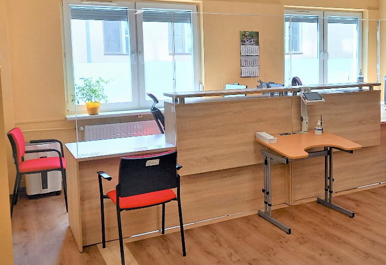 Pomieszczenie Centrum Wsparcia, miejsce przyjmowania dokumentów oraz obsługi studentów. Na zdjęciu dwa stanowiska do obsługi studentów, jedno wyposażone w lupę elektroniczną udźwiękowioną oraz stolik dla osób poruszających się na wózku inwalidzkim.